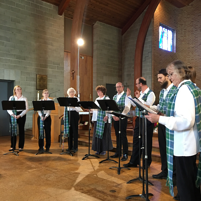 people standing at the front of a church singing