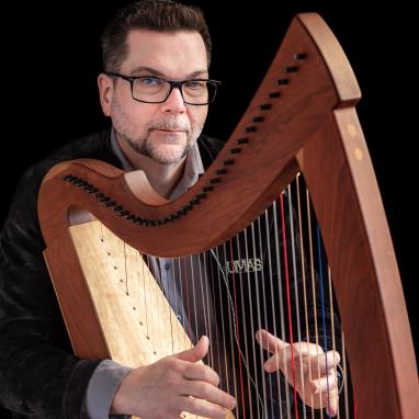 man playing folk harp